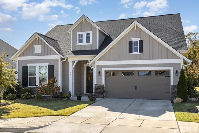 a view of a white house with large windows and plants