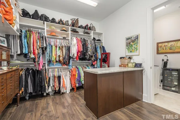 a view of walk in closet with clothes and shoes
