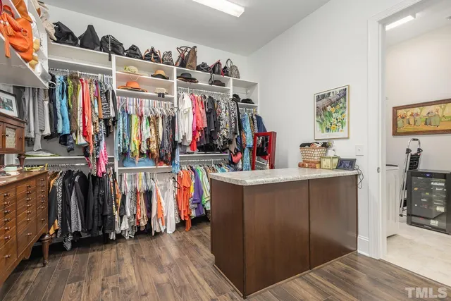 a view of walk in closet with clothes and shoes