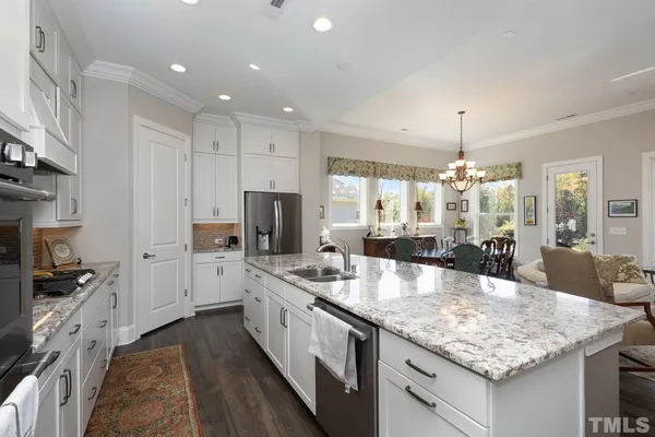 a large white kitchen with a stove and a sink