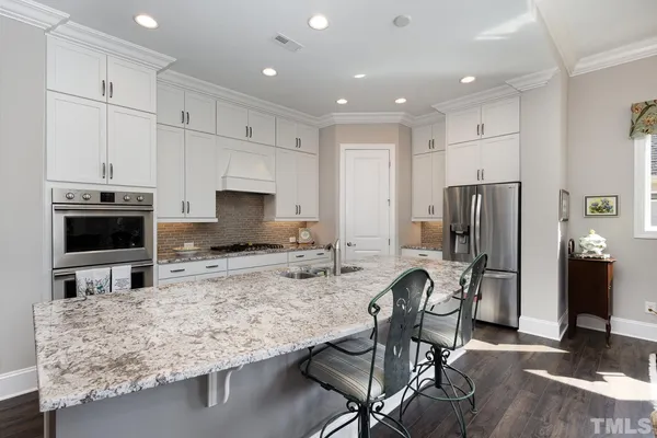 a kitchen with stainless steel appliances granite countertop a stove refrigerator and a microwave