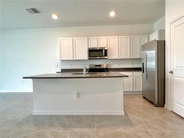 a kitchen with granite countertop a sink and white cabinets