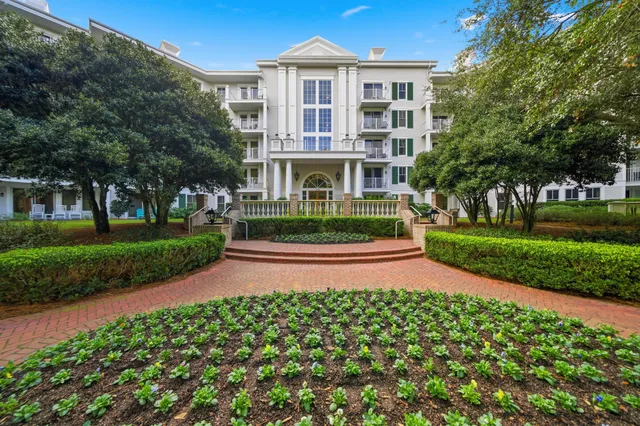 a front view of a house with a yard and potted plants