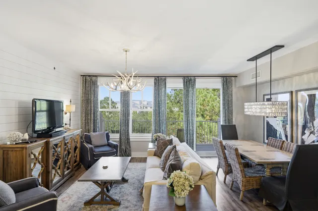 a living room with furniture a flat screen tv and a large window