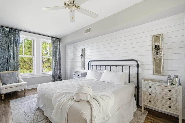 a large bed sitting in a bedroom next to a window with a dresser