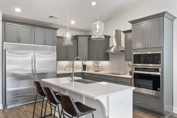 a kitchen with stainless steel appliances a sink stove and refrigerator