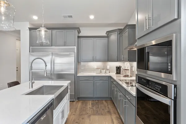 a kitchen with a sink stove top oven and refrigerator