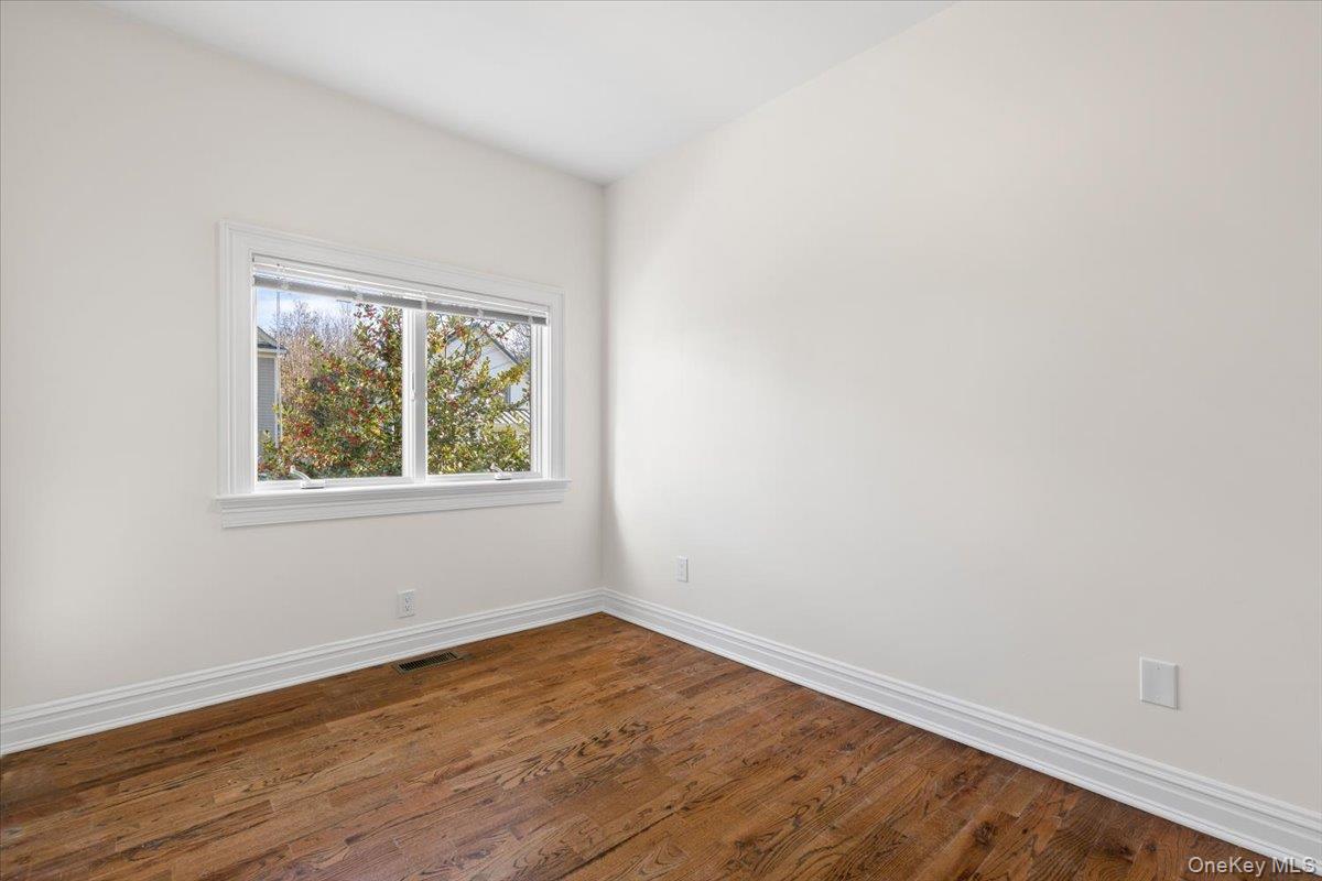 397 Midland Avenue, Unit 397 Rye, NY 10580 - Photo 6 of 16 an empty room with wooden floor and windows