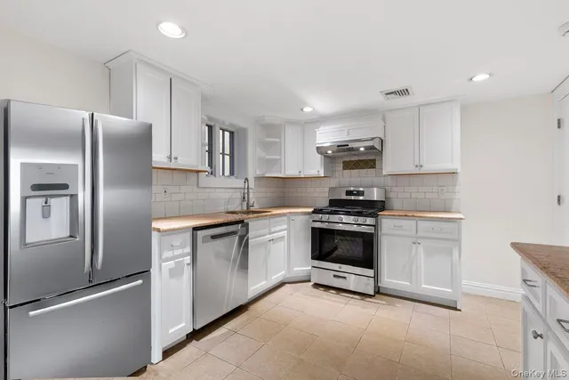 a kitchen with stainless steel appliances granite countertop a refrigerator stove and sink