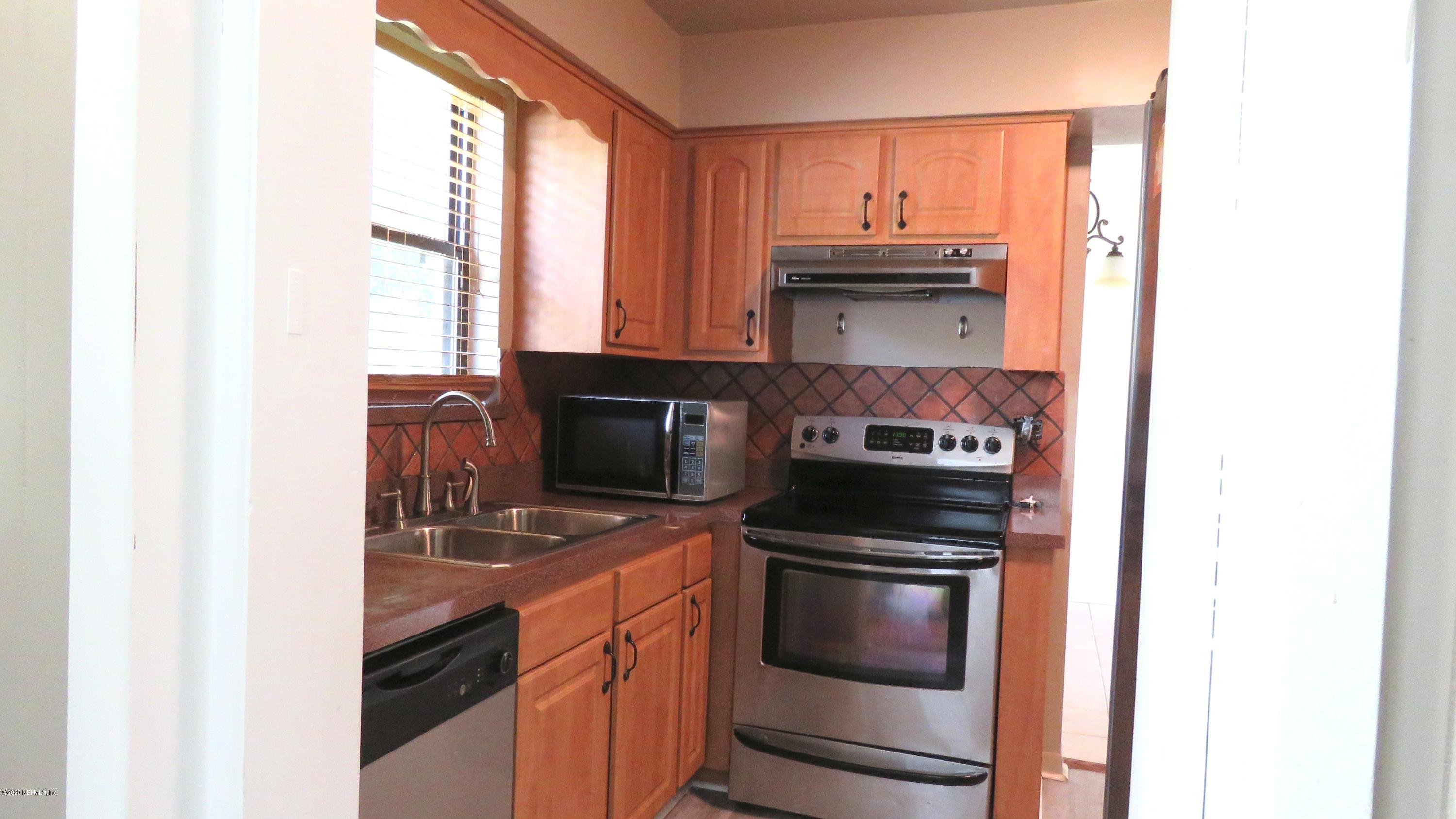 4715 Spring Park Road Jacksonville, FL 32207 - Photo 11 of 12 a kitchen with stainless steel appliances granite countertop a stove and a microwave