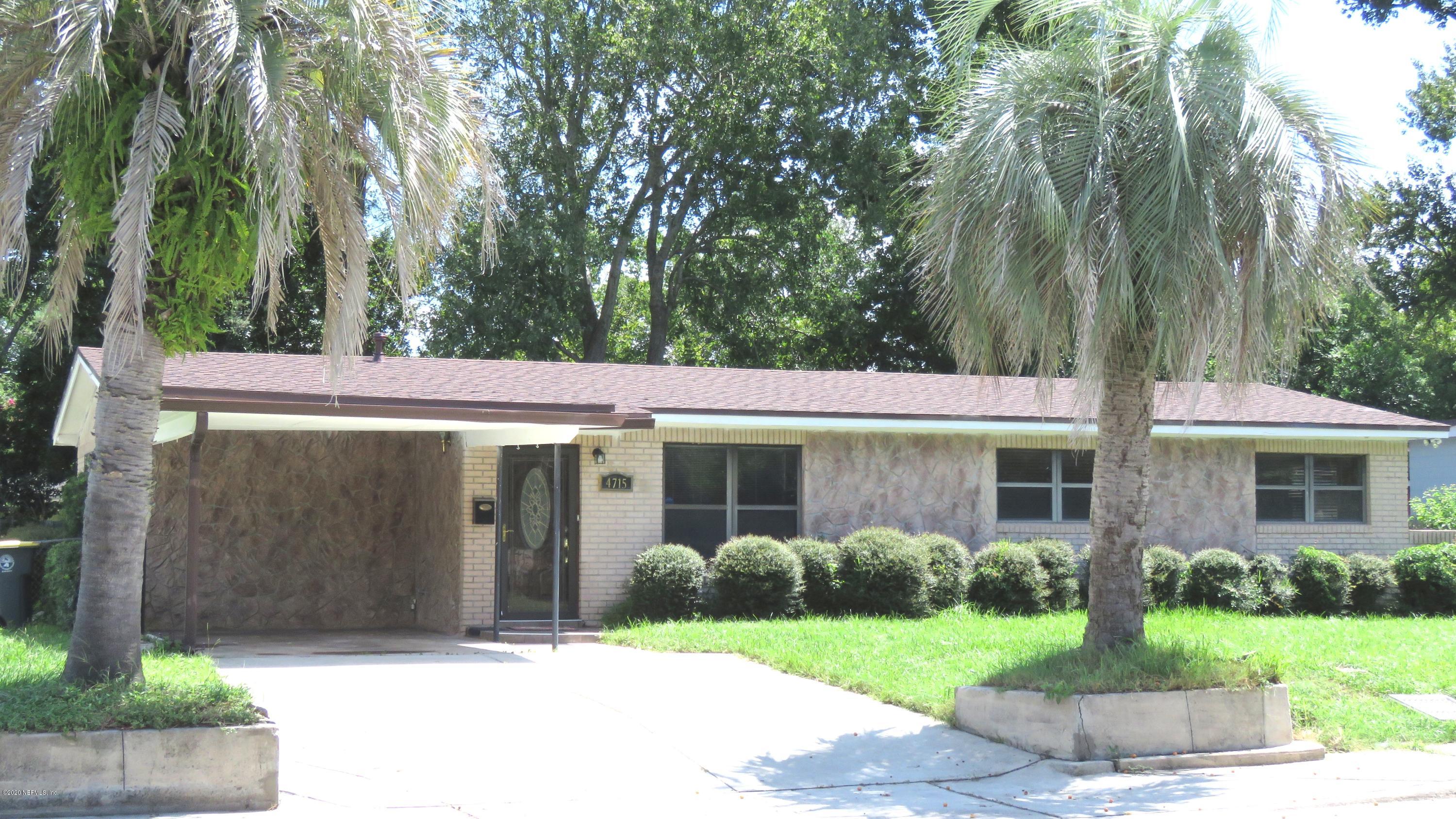 4715 Spring Park Road Jacksonville, FL 32207 - Photo 3 of 12 a view of a white house with a big yard and large trees