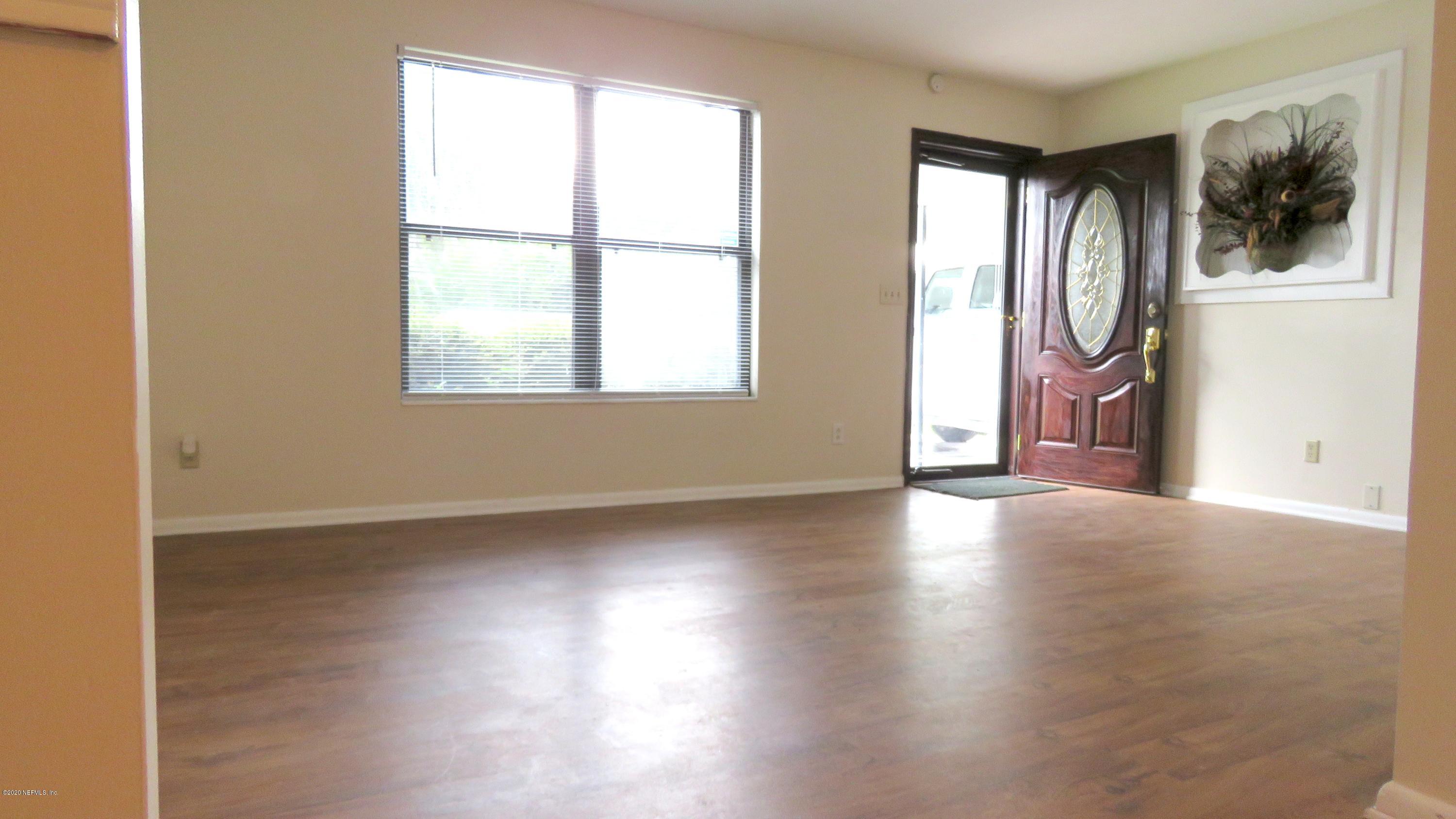 4715 Spring Park Road Jacksonville, FL 32207 - Photo 8 of 12 an empty room with wooden floor and windows