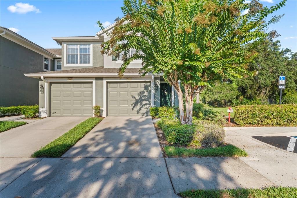 a front view of a house with a yard and a garage