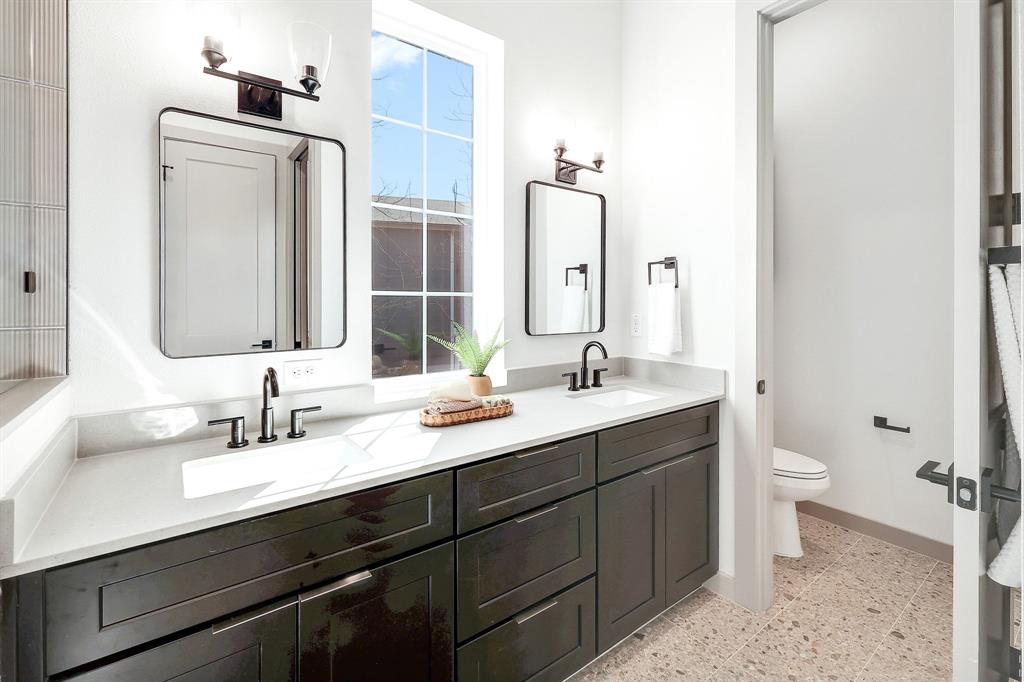 1732 Bunche Road, Unit B2 Austin, TX 78721 - Photo 13 of 22 a bathroom with a double vanity sink toilet and mirror