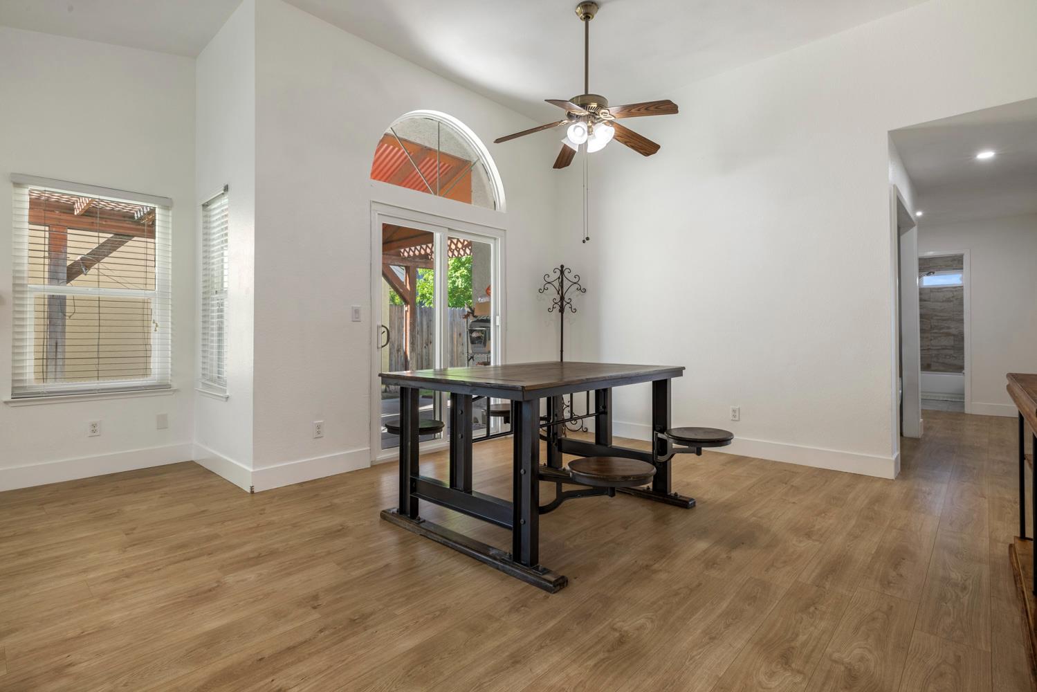 9488 Dunkerrin Way Elk Grove, CA 95758 - Photo 16 of 43 a dining room with wooden floor a chandelier a glass table and chairs