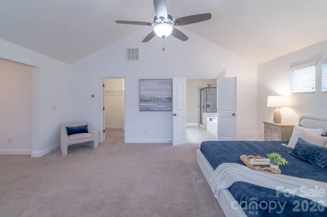 a spacious bedroom with a bed and ceiling fan