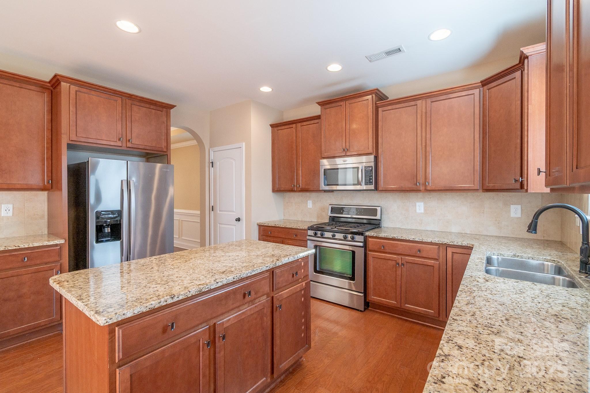 2003 Fallondale Road Waxhaw, NC 28173 - Photo 7 of 27 a kitchen with stainless steel appliances granite countertop a sink stove refrigerator and cabinets