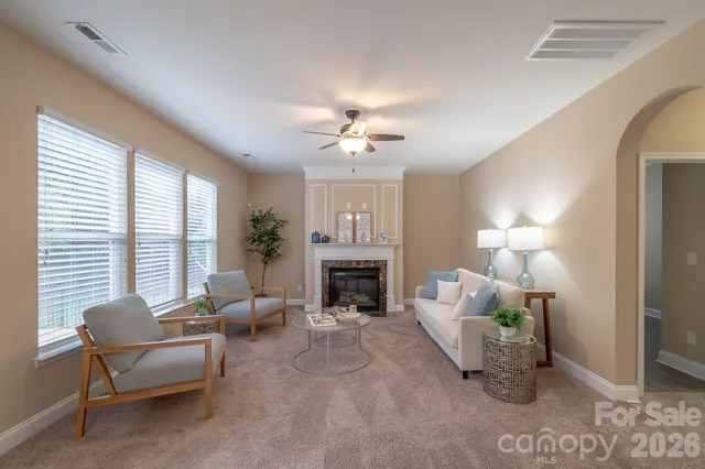 a living room with furniture a fireplace and a chandelier