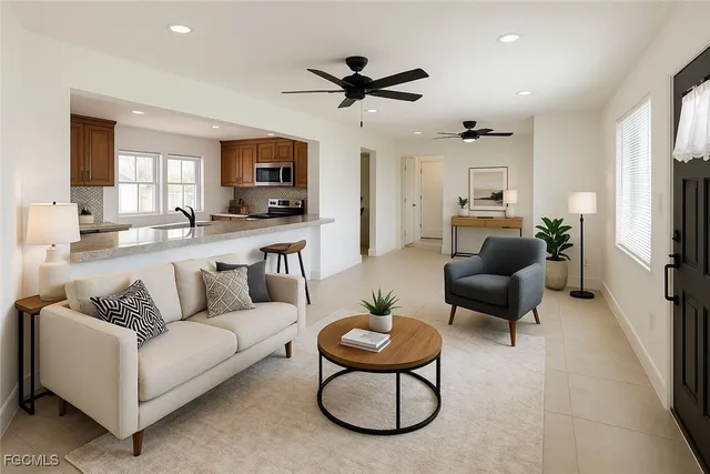 a living room with furniture a flat screen tv and a window