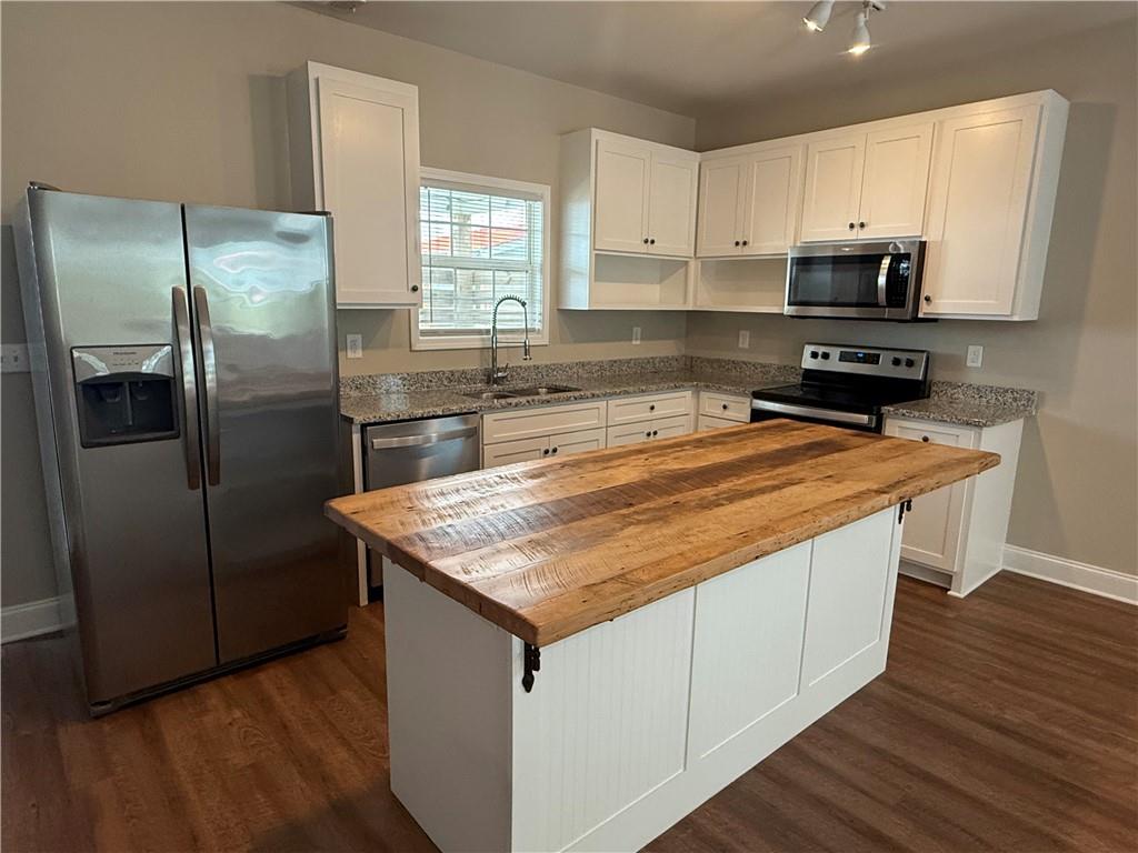 78 Liberty Court Gainesville, GA 30501 - Photo 7 of 13 a kitchen with stainless steel appliances granite countertop a refrigerator a sink a stove a microwave and wooden cabinets