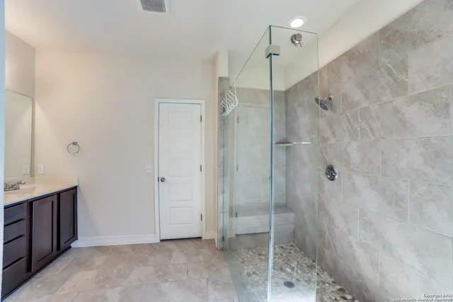 a bathroom with a sink a toilet a mirror and shower