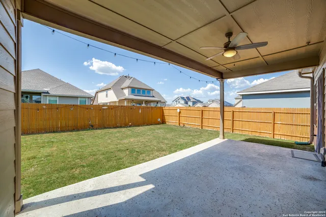 a backyard of a house with large trees and barbeque oven