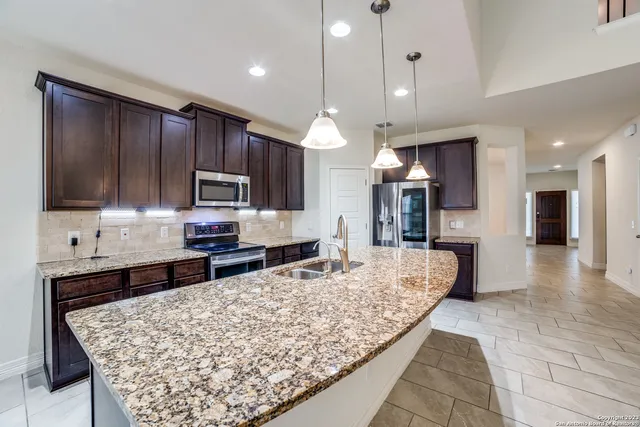 a large kitchen with kitchen island granite countertop a large counter top stainless steel appliances and cabinets