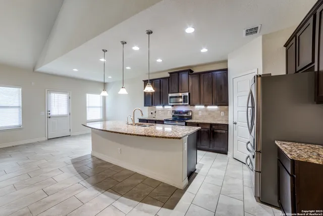 a kitchen with stainless steel appliances granite countertop a sink stove and refrigerator