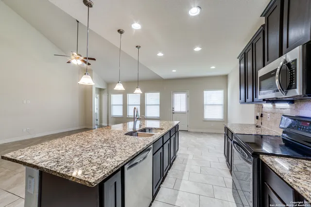 a view of living room kitchen with stainless steel appliances cabinets