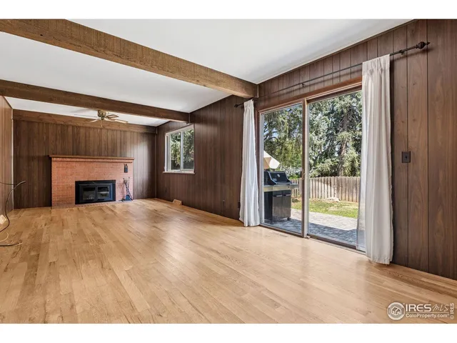 a view of an empty room with a fireplace and a window