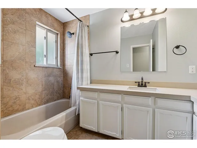 a bathroom with a tub a sink and mirror