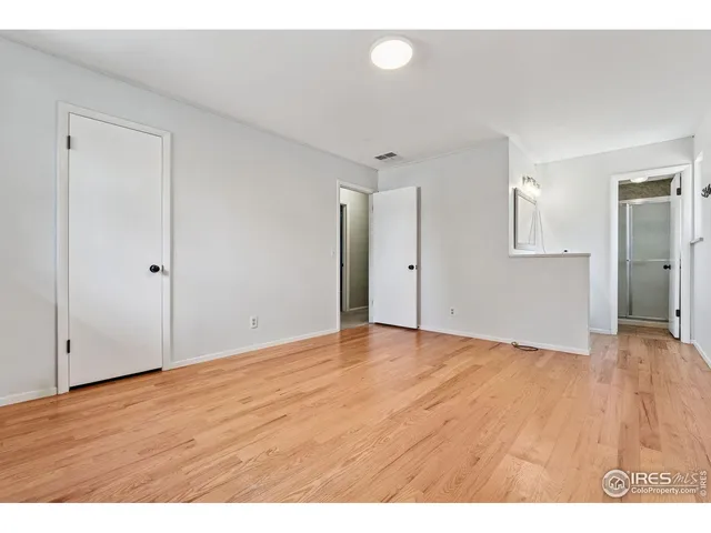 a view of an empty room with wooden floor