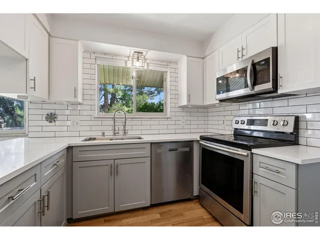 a kitchen with stainless steel appliances granite countertop a sink stove and microwave
