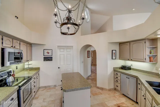 a kitchen with stainless steel appliances granite countertop a stove a sink dishwasher and a refrigerator with wooden floor