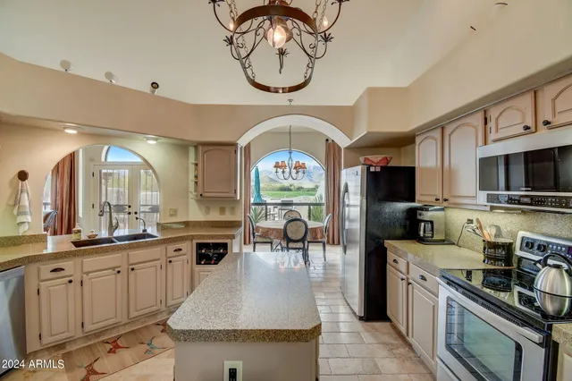 a kitchen with stainless steel appliances granite countertop a stove a sink and a refrigerator