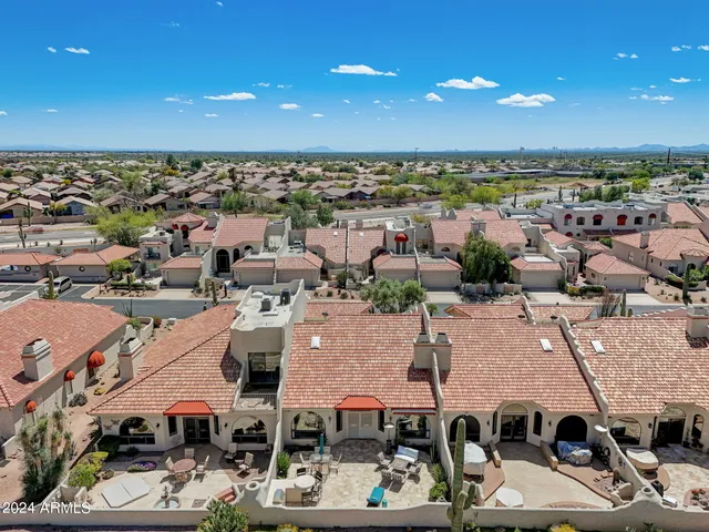 a patio with table and chairs with wooden floor and fence