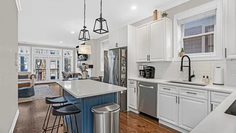 a kitchen with white cabinets and stainless steel appliances