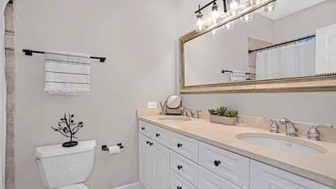 a bathroom with a granite countertop toilet sink and mirror