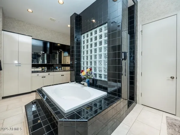 a room with kitchen island a sink stainless steel appliances and cabinets