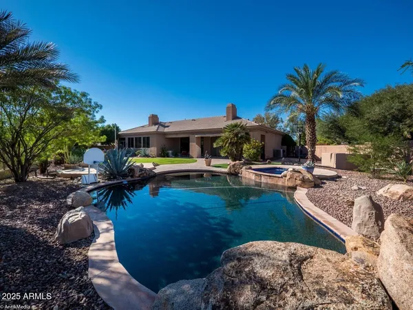 a view of a house with pool and sitting area