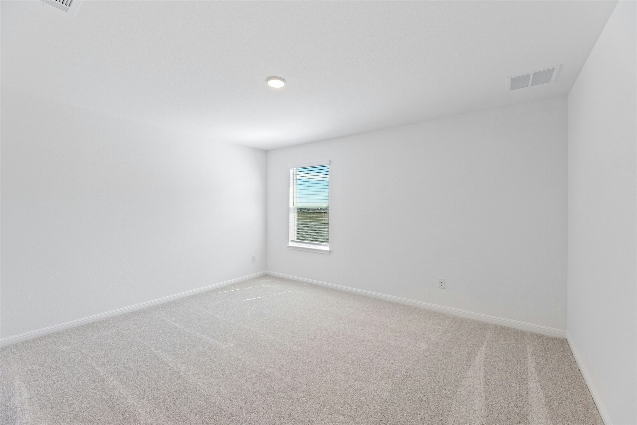 2001 Wynn Road Hutto, TX 78634 - Photo 27 of 39 A spacious and neutral bedroom featuring soft carpet and a naturally illuminated window, perfect for quiet retreats.