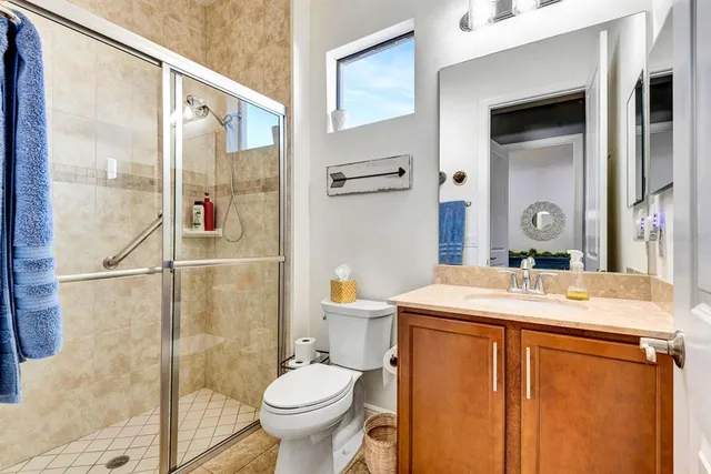 a bathroom with a sink a toilet a mirror and shower