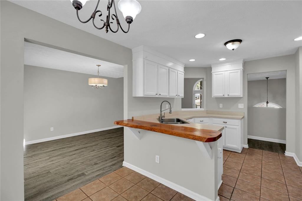 281 Cedars Glen Circle Villa Rica, GA 30180 - Photo 13 of 52 a kitchen with kitchen island granite countertop a sink a counter space and cabinets