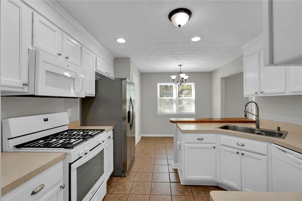 281 Cedars Glen Circle Villa Rica, GA 30180 - Photo 15 of 52 a kitchen with kitchen island white cabinets a sink a stove and a refrigerator