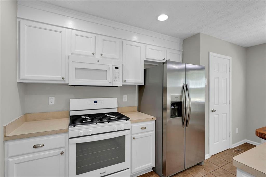 281 Cedars Glen Circle Villa Rica, GA 30180 - Photo 17 of 52 a kitchen with white cabinets and stainless steel appliances