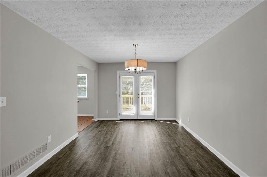 281 Cedars Glen Circle Villa Rica, GA 30180 - Photo 10 of 52 an empty room with wooden floor chandelier and windows