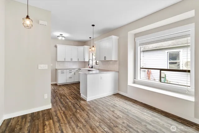 a kitchen with a refrigerator and white cabinets