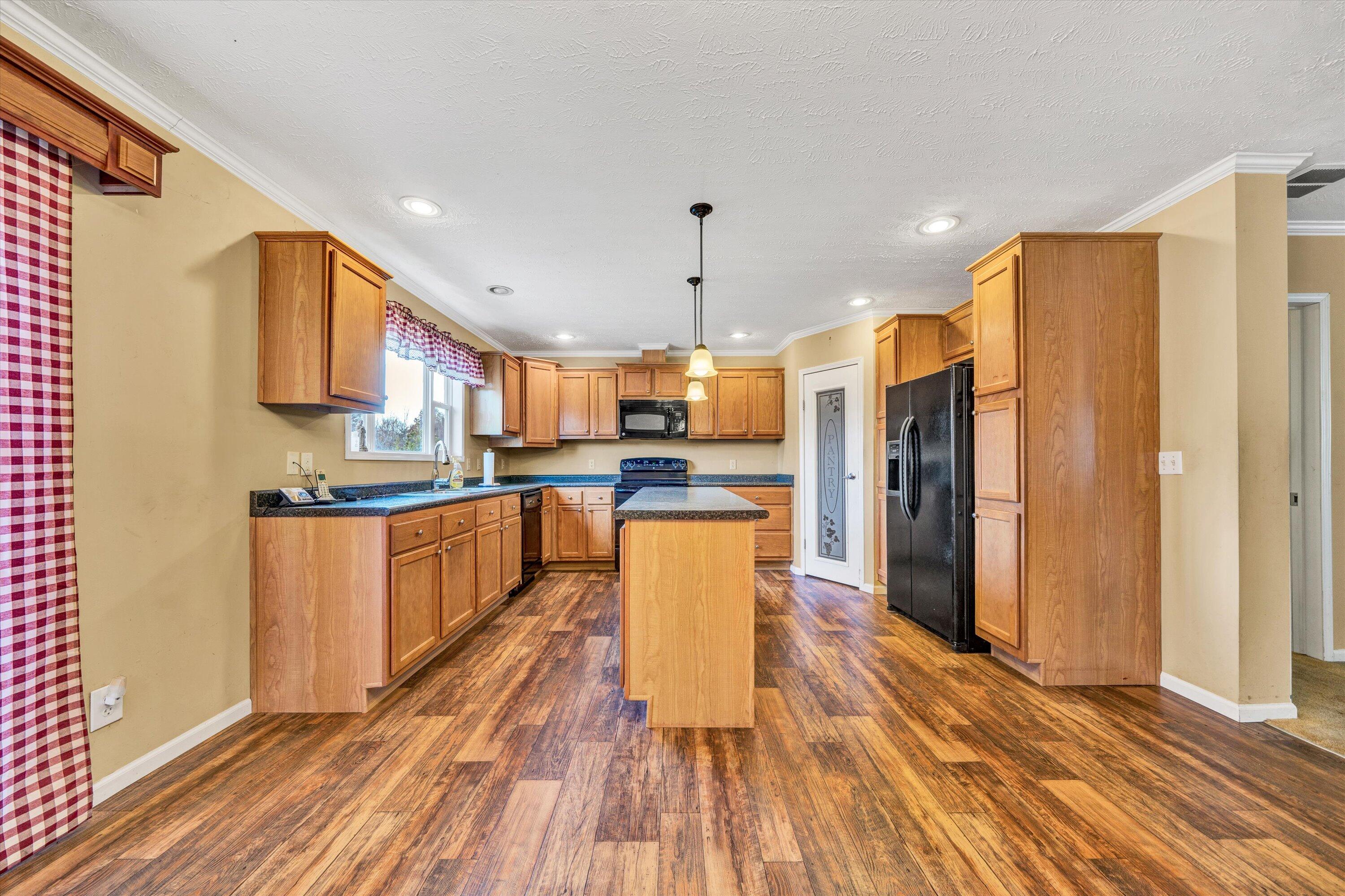 590 Belcher Road Penhook, VA 24137 - Photo 7 of 23 a kitchen with stainless steel appliances granite countertop a refrigerator a stove top oven a sink dishwasher and a refrigerator with wooden floor