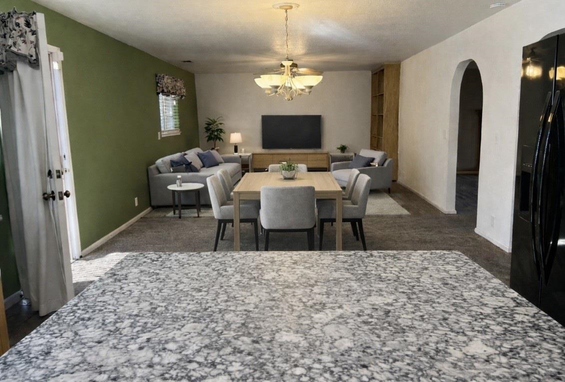 3816 Teek Court Ceres, CA 95307 - Photo 5 of 21 Dining area with arched walkways, suspended lighting, and dark carpet