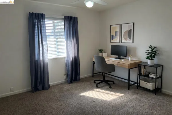 a view of a workspace with furniture and a window